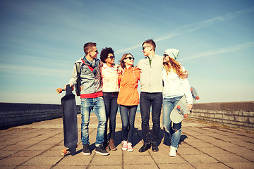 Image showing happy teenage friends with longboards on street