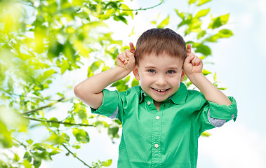 Image showing happy little boy having fun and making horns