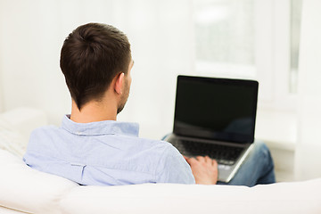 Image showing close up of man typing on laptop computer at home