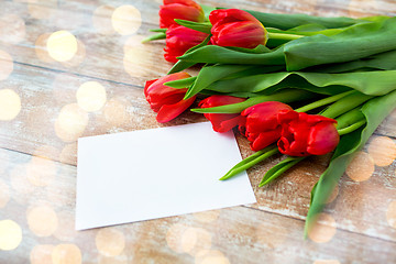 Image showing close up of red tulips and blank paper or letter