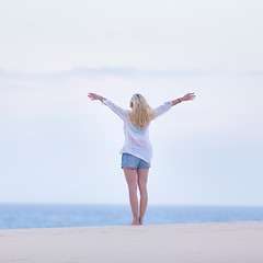 Image showing Free woman enjoying freedom on beach in morning.