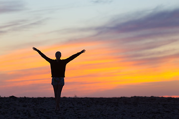 Image showing Woman enjoying freedom at sunset.