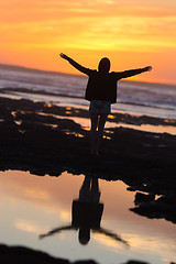 Image showing Free woman enjoying freedom on beach at sunset.