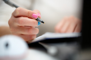 Image showing female hands with pen writing on notebook