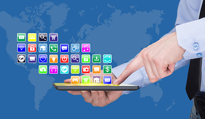 Image showing Businessman holding a tablet pc with mobile applications icons on virtual screen . Internet and business concept.