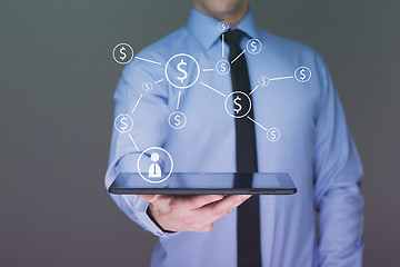 Image showing businessman holding a tablet pc with dollar icons. Internet and business concept. 