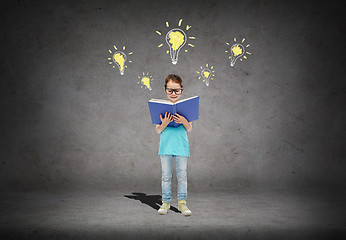 Image showing happy little girl in eyeglasses reading book