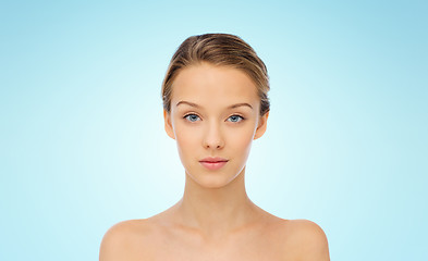 Image showing young woman face with bare shoulders over blue