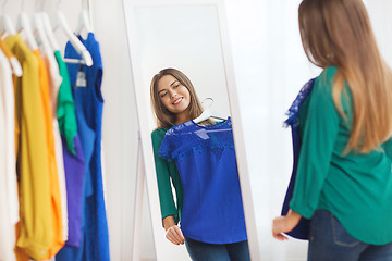 Image showing happy woman choosing clothes at home wardrobe