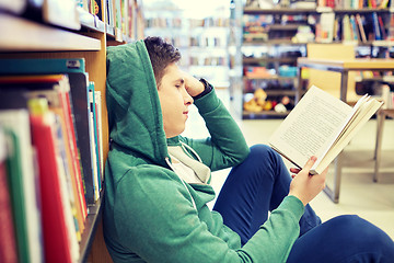 Image showing student boy or young man reading book in library