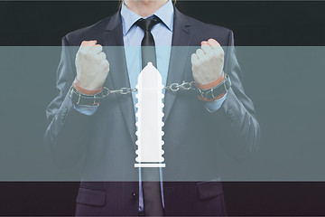 Image showing man in a business suit with chained hands. handcuffs for sex games. concept of erotic entertainment.