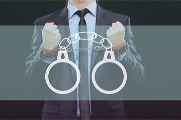 Image showing man in a business suit with chained hands. handcuffs for sex games. concept of erotic entertainment.