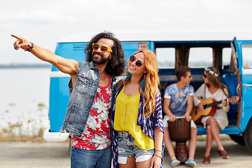 Image showing smiling young hippie couple over minivan car