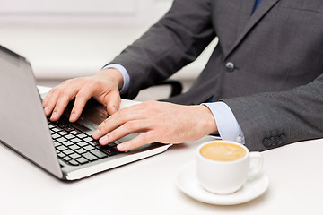 Image showing close up of businessman with coffee and laptop