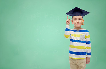 Image showing happy boy in bachelor hat pointing finger up