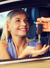 Image showing happy woman getting car key in auto show or salon