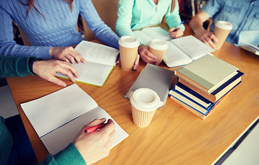 Image showing close up of hands with books writing to notebooks