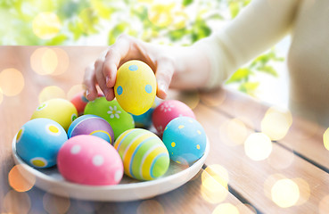 Image showing close up of woman hands with colored easter eggs