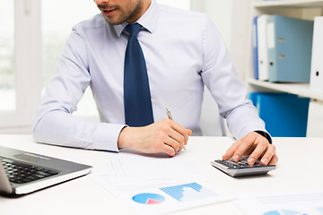 Image showing close up of businessman with laptop and papers