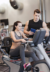 Image showing woman with trainer on exercise bike in gym