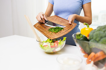 Image showing close up of woman with chopped onion cooking salad