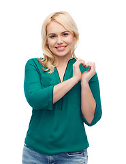 Image showing smiling young woman in shirt showing heart shape