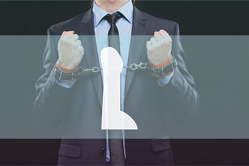 Image showing man in a business suit with chained hands. handcuffs for sex games. concept of erotic entertainment.