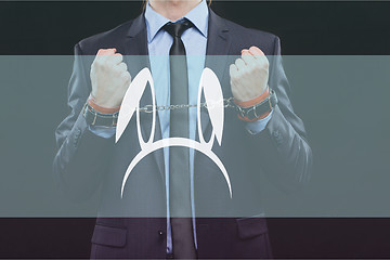 Image showing man in a business suit with chained hands. handcuffs for sex games. concept of erotic entertainment.