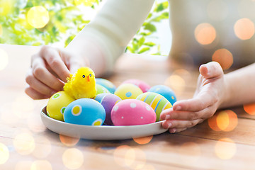 Image showing close up of woman hands with colored easter eggs