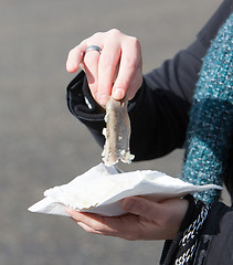 Image showing Dutch woman is eating typical raw herring