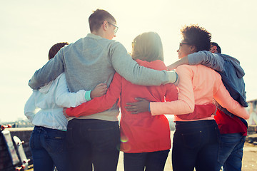 Image showing group of happy teenage friends hugging on street