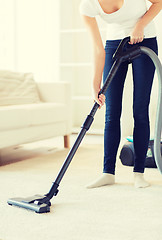 Image showing close up of woman with vacuum cleaner at home