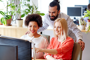 Image showing happy creative team with computer in office