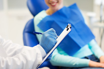 Image showing close up of dentist with clipboard and patient
