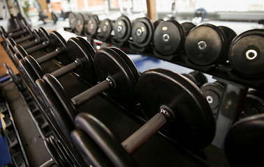 Image showing close up of dumbbells and sports equipment in gym