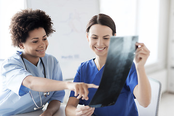 Image showing happy female doctors with x-ray image at hospital