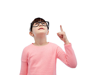 Image showing happy little girl in eyeglasses pointing finger up