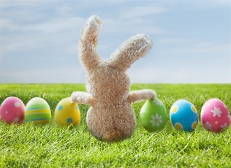 Image showing close up of colored easter eggs and bunny on grass