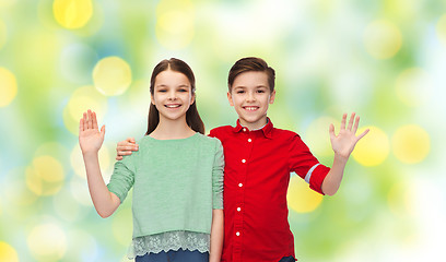 Image showing happy boy and girl waving hand