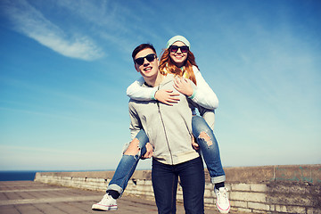 Image showing happy teenage couple in shades having fun outdoors