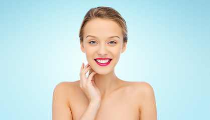 Image showing smiling young woman with pink lipstick on lips