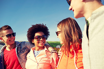 Image showing happy teenage friends in shades talking on street