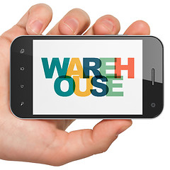 Image showing Industry concept: Hand Holding Smartphone with Warehouse on  display