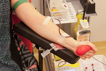 Image showing Donor in an armchair donates blood