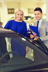 Image showing happy woman with car dealer in auto show or salon