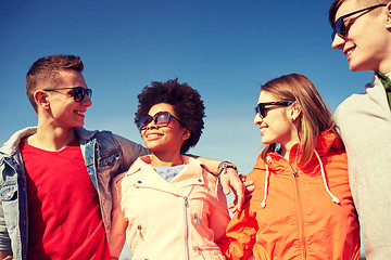 Image showing happy teenage friends in shades talking on street