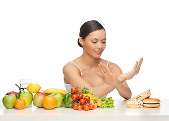 Image showing woman with fruits rejecting hamburger