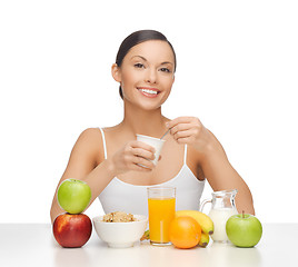 Image showing young woman eating healthy breakfast