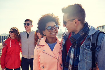 Image showing happy teenage friends in shades talking on street