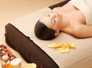 Image showing woman in spa salon lying on the massage desk